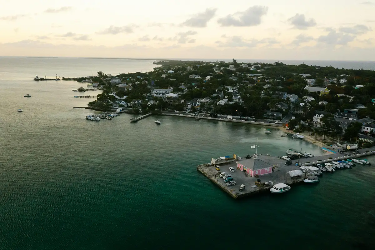 Aerial view of a coastal harbor town at sunset.