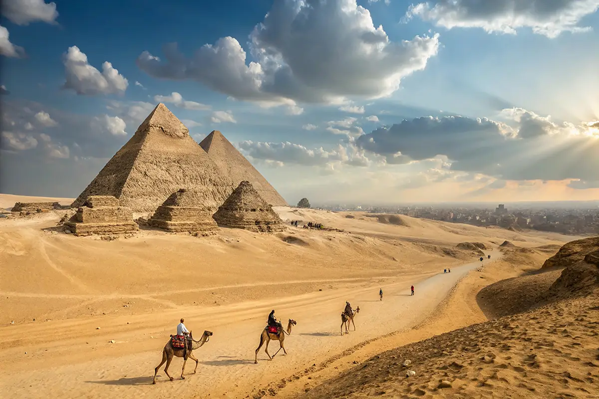 People riding camels with the Giza pyramids in the background, in Egypt.