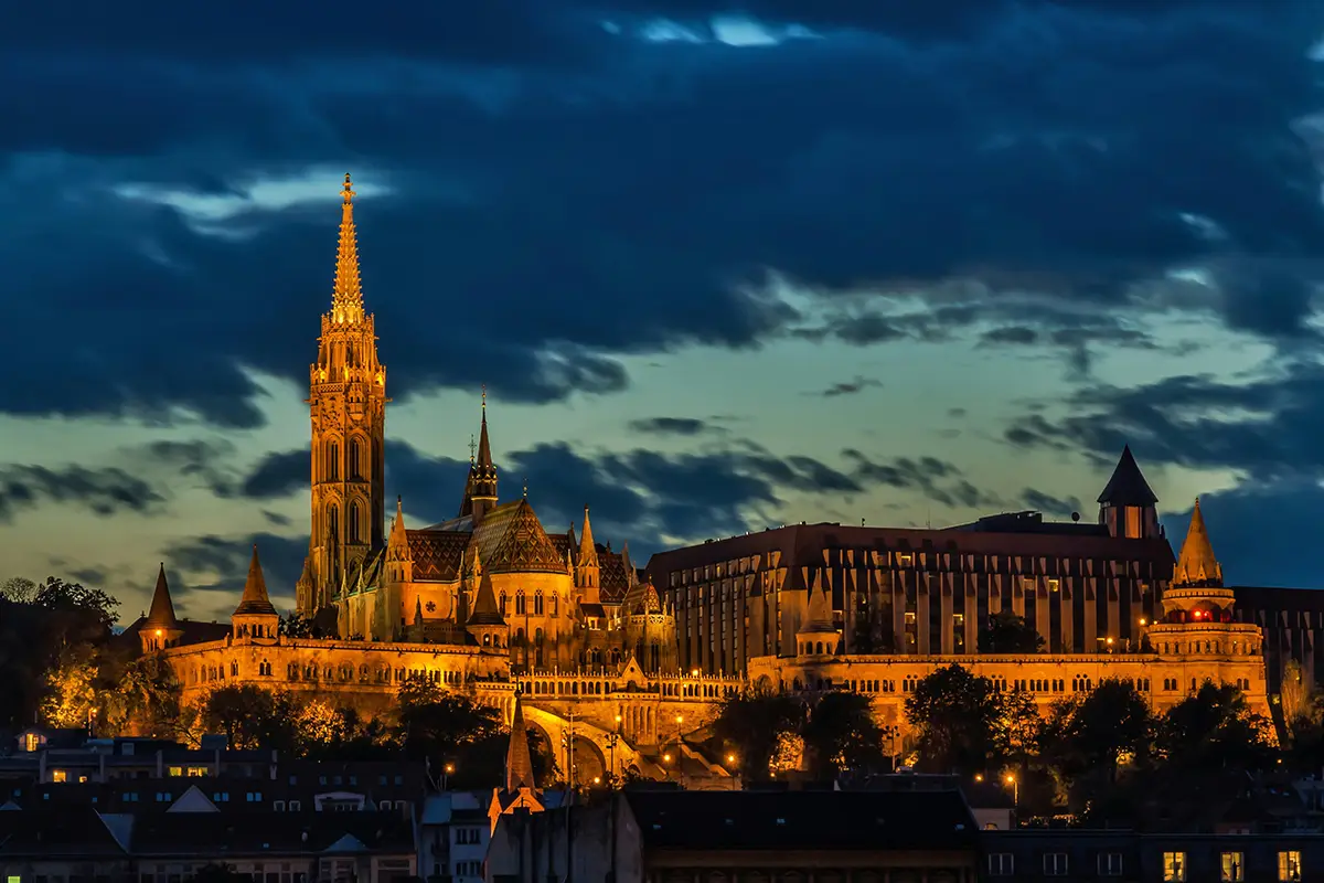 Illuminated castle and towers at dusk.