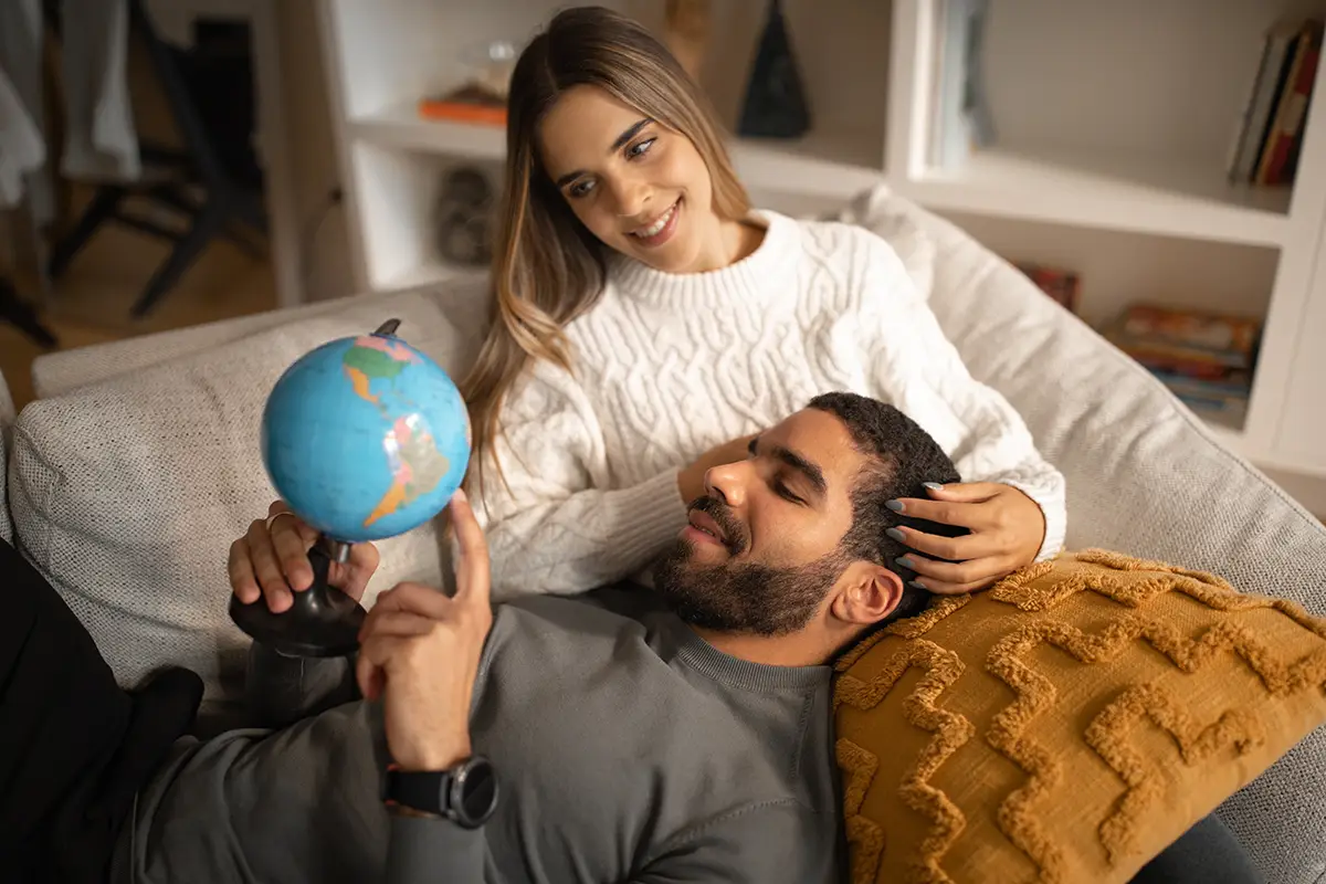 Couple looking at the globe, choosing the next residency. Residency vs. Citizenship.