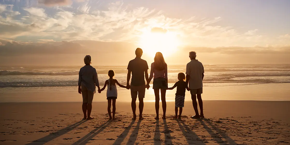 Whole family generation standing by the beach.