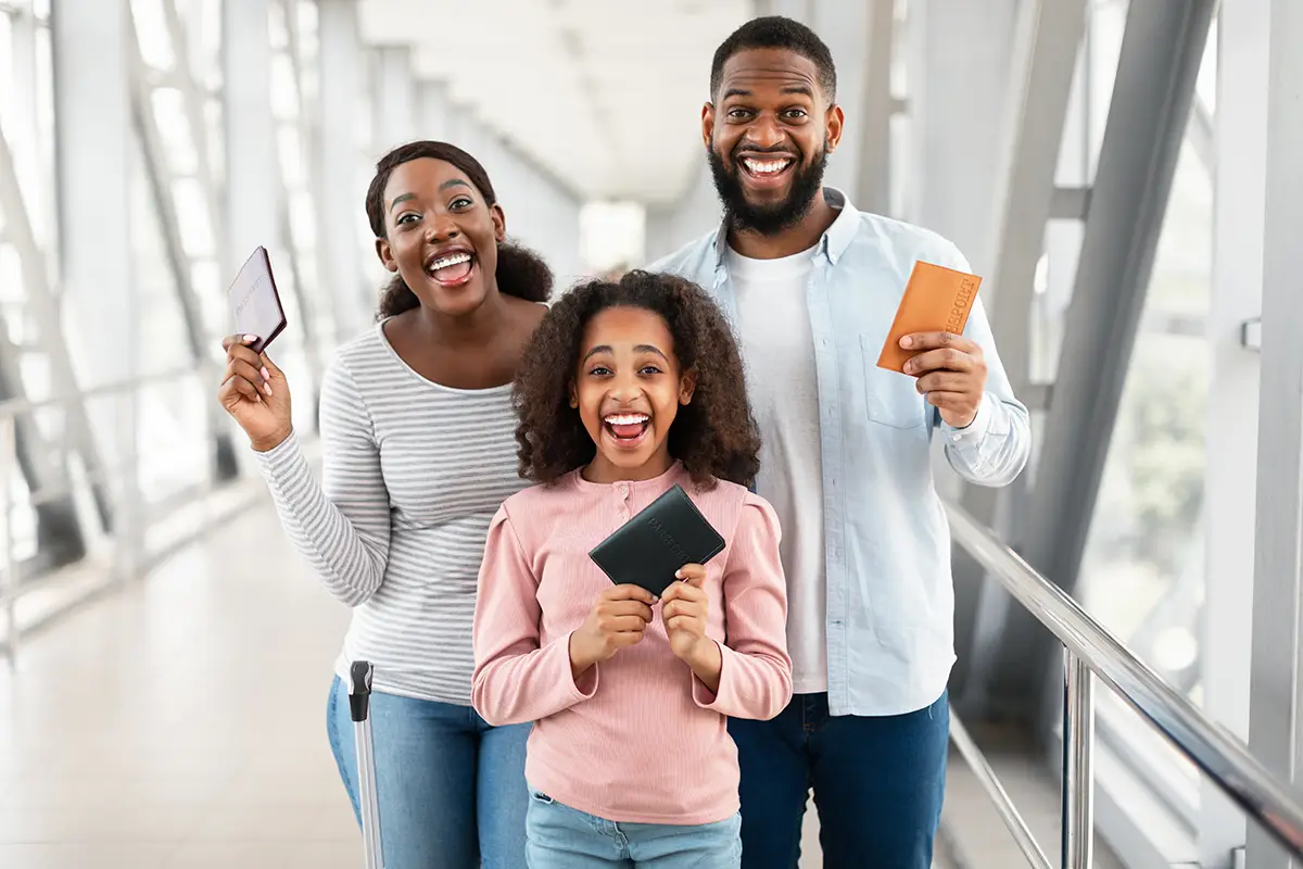 Happy family holding their passports gained from a family reunification visa.