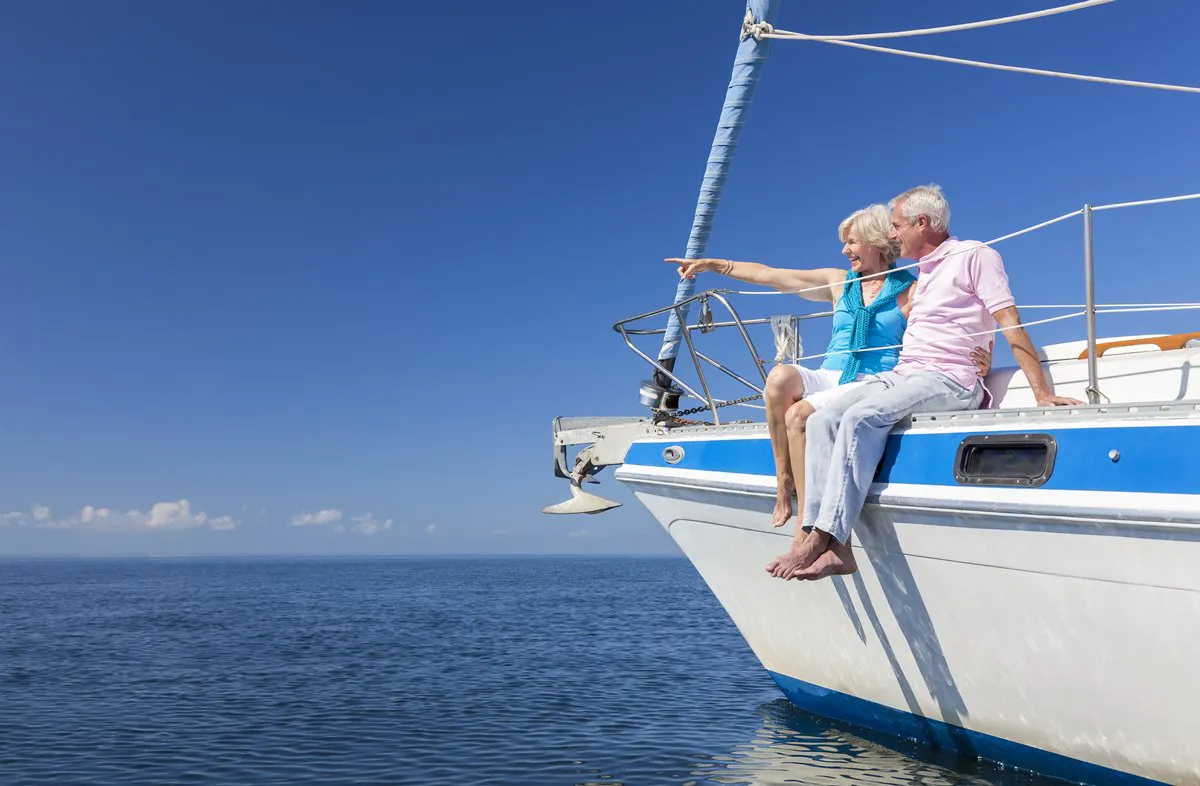 Elderly couple enjoying retirement on a yacht.